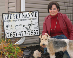 Betty with her dog standing in front of the Pet Nannie sign